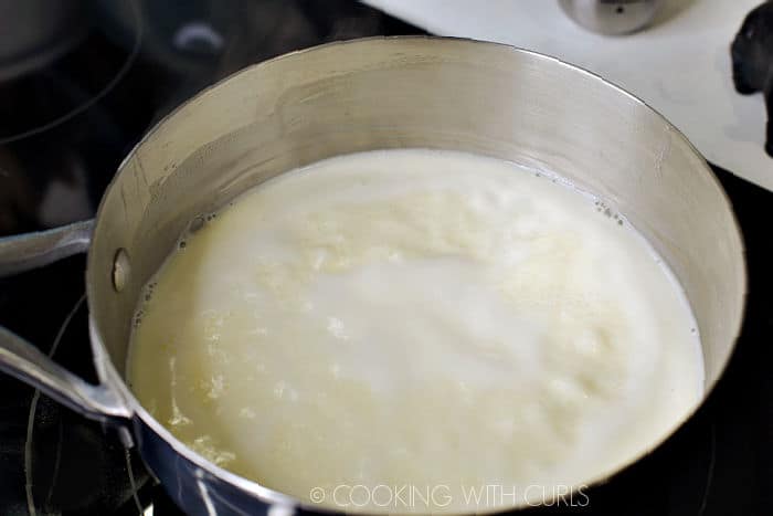 Cream and sugar mixture simmering in a saucepan. 