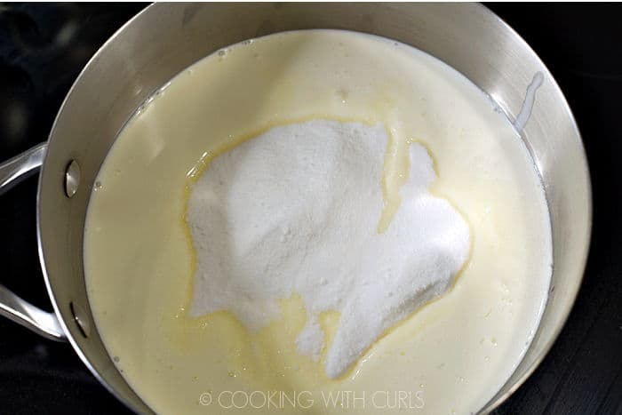 Granulated sugar poured into heavy cream in a saucepan. 