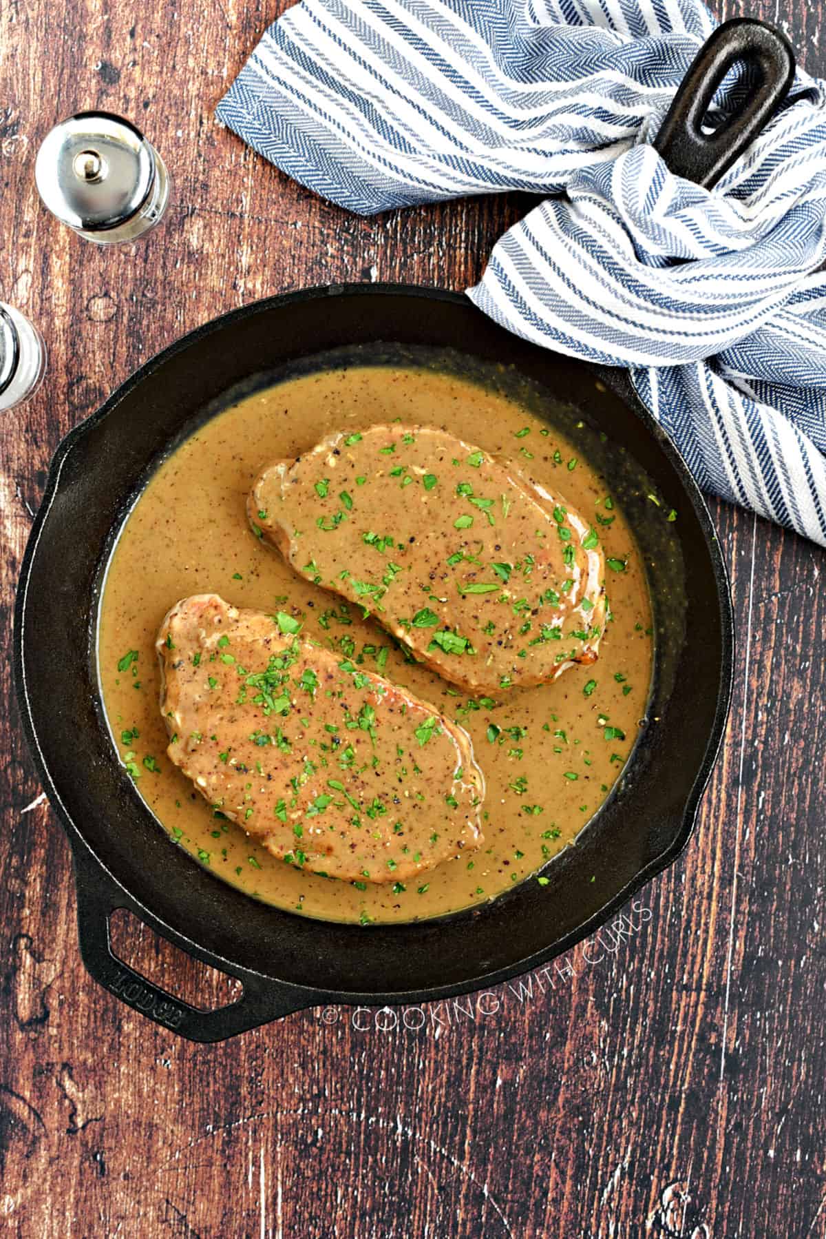 Looking down on two Pork Chops covered with Pan Gravy.