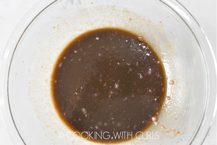 Balsamic vinaigrette whisked together in a glass bowl.