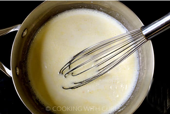 Milk, melted butter and flour in a saucepan with a wire whisk on the edge. 