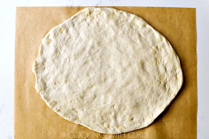 Pizza dough on parchment paper. 