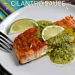 Baked salmon filet topped with cilantro sauce and lime wedges on a white plate with title graphic across the top.