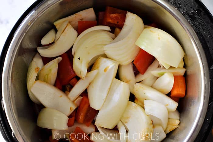 Chopped vegetables on top of the cooked pot roast in an Instant Pot. 