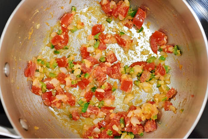 Diced onion, tomato and jalapeno in a saucepan. 