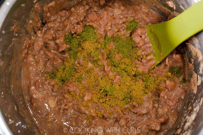 Ground oregano and cumin added to the mashed pinto beans. 