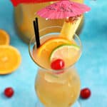 A hurricane glass filled with Jamaican Rum Punch and garnished with slices of orange and lime with a cherry and a pineapple slice with a pink paper umbrella on the rim and title graphic across the top.