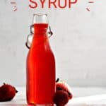 Strawberry Simple Syrup in a square bottle with three fresh strawberries around the base of the bottle with title graphic across the top.