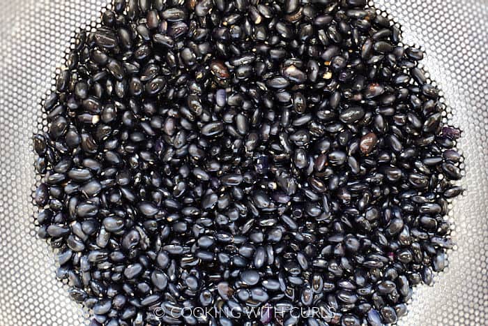 Dry black beans rinsed and drained in a metal colander. 