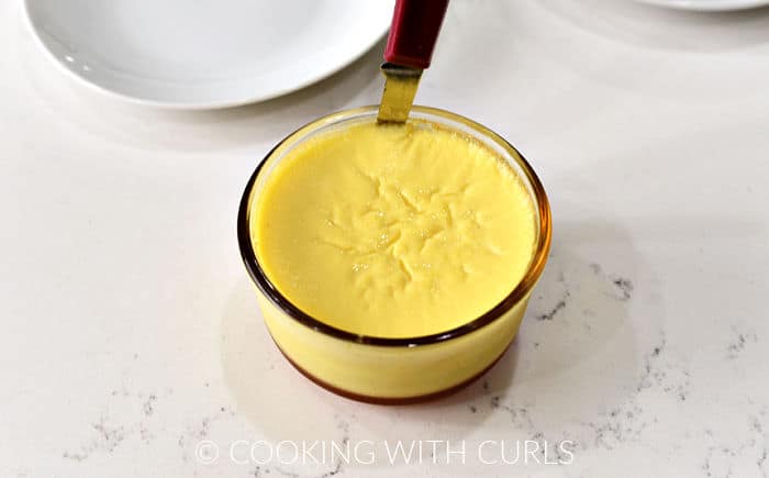 A thin knife sticking up between the custard and the glass up to loosen it from the sides. 