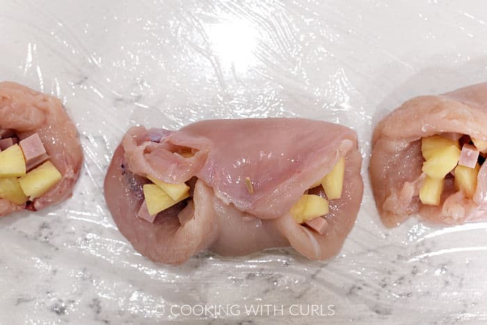 Chicken breasts wrapped around pineapple and ham chunks with a toothpick to hold the ends together. 
