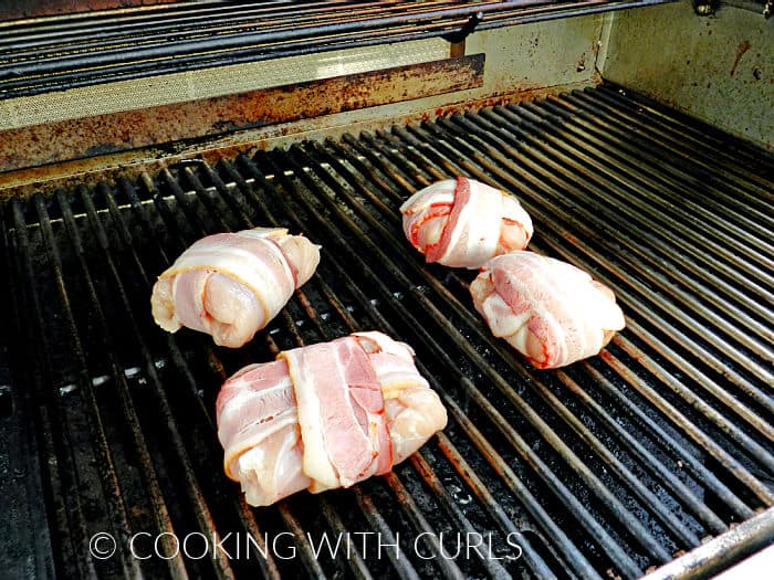 Four bacon wrapped Hawaiian Chicken Grillers on the grill. 
