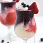 Layered Berry Pina Colada with blue, white, and red layers in two hurricane glasses with title graphic across the top.