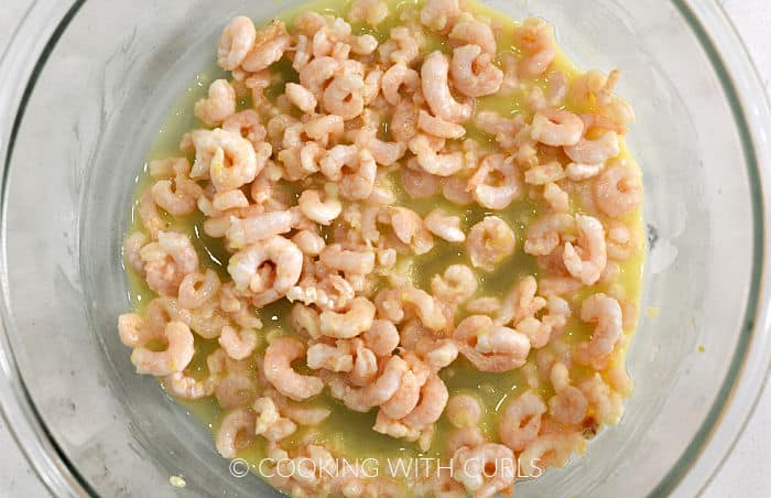 Shrimp and garlic butter mixture in a glass bowl.
