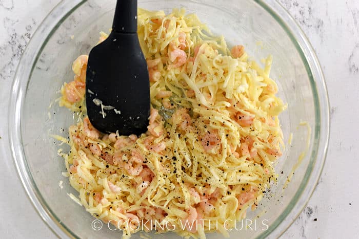 Shrimp, garlic butter, lemon and grated cheeses mixed together in a glass bowl. 