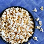 instant pot kettle corn in a blue bowl on a blue background.