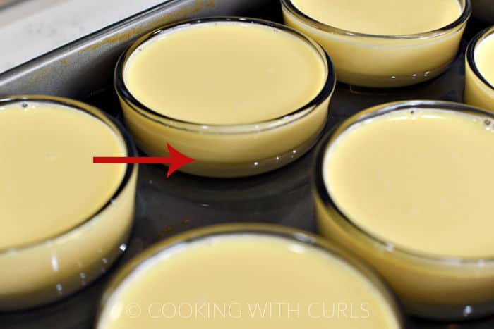 Water filled halfway up the custard cups in a baking pan. 