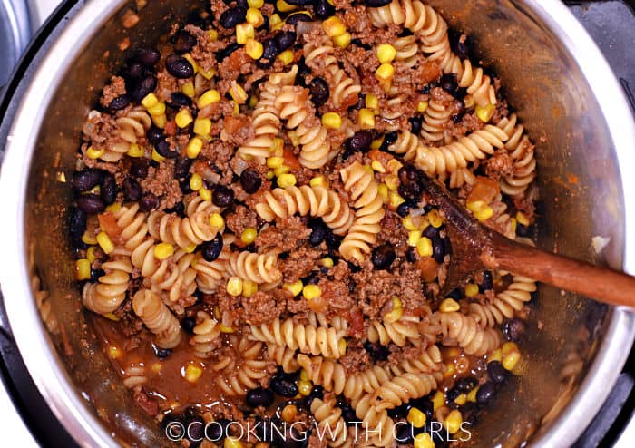 Cooked pasta, beans, corn, and salsa in a pressure cooker. 