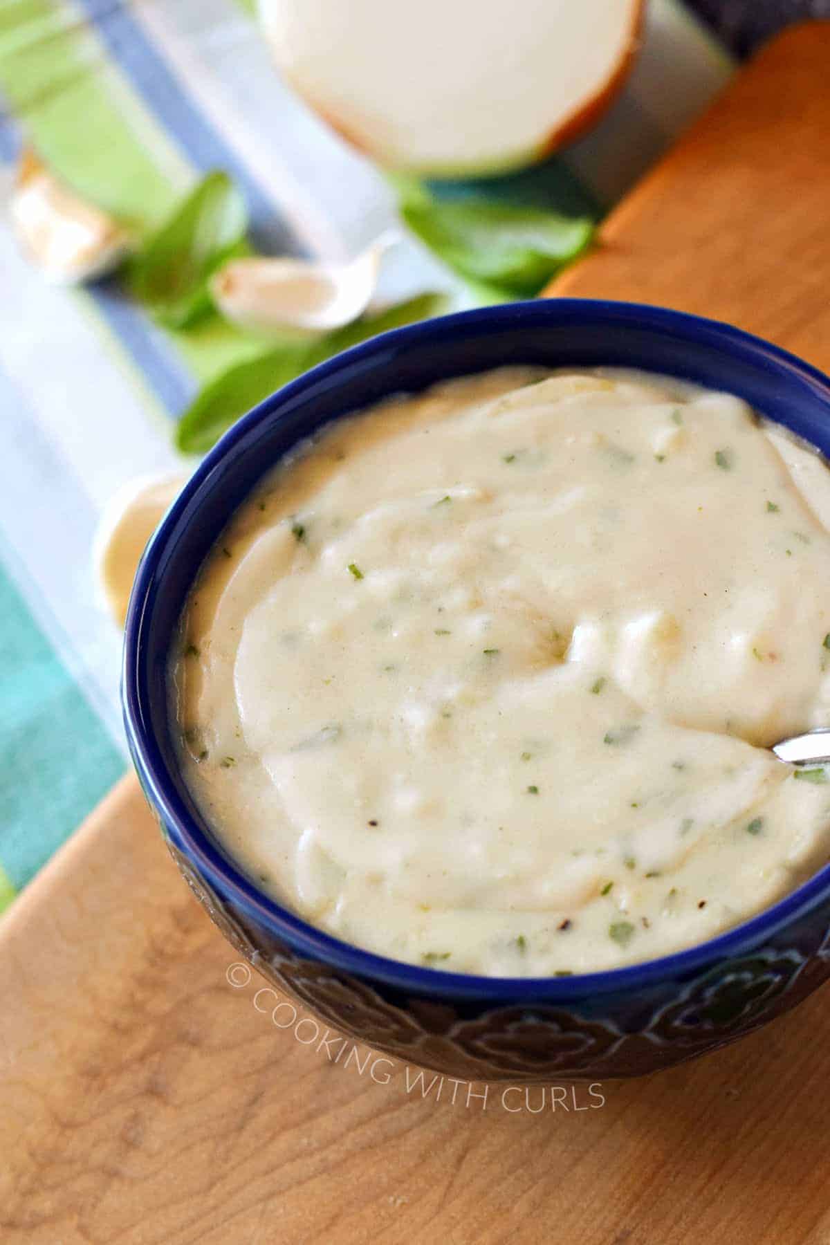 Creamy white pizza sauce in a blue bowl.