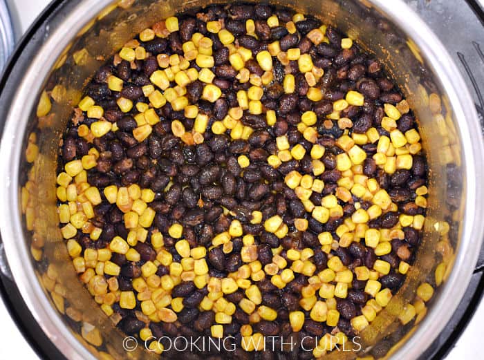 Looking down on cooked beans and corn in a pressure cooker. 