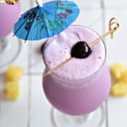 Frozen pink cocktail with a blue umbrella and fresh cherry on a bamboo stick and title graphic across the top.