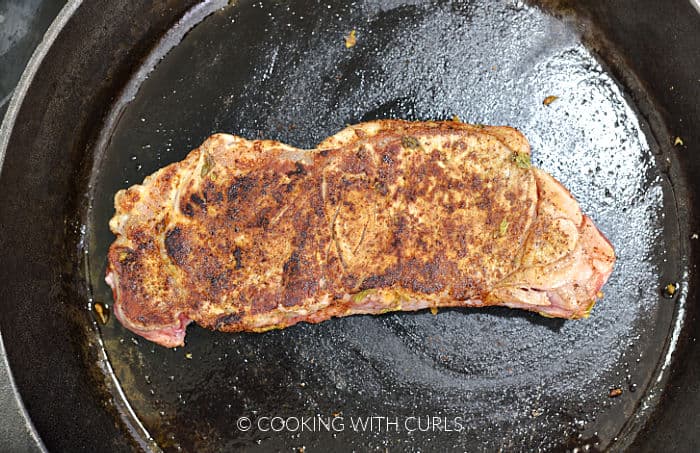 Seasoned steak cooked in a cast iron skillet. 