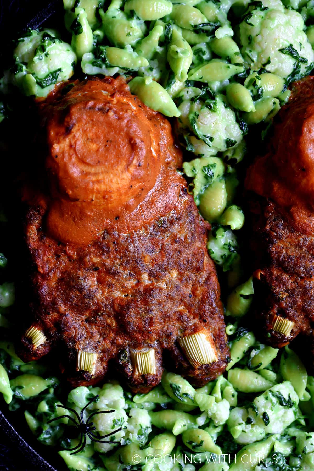 Meatloaf Feet sitting on green mac and cheese. 