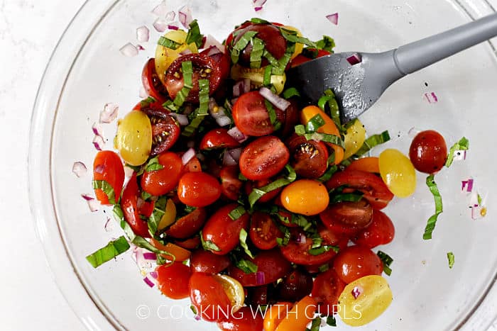 Cherry tomato halves, strips of fresh basil, diced red onion, lemon juice, salt and pepper tossed together in a medium bowl. 