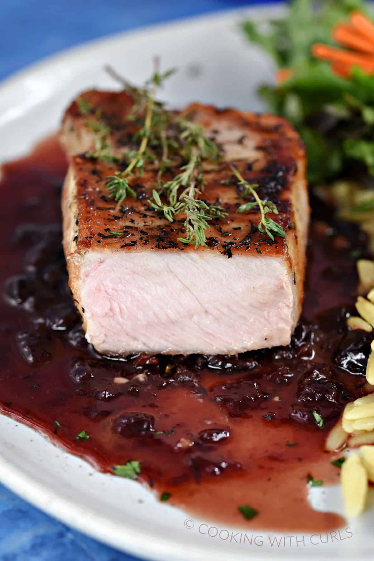 Cut Pork Chop topped with Cherry Sauce. 