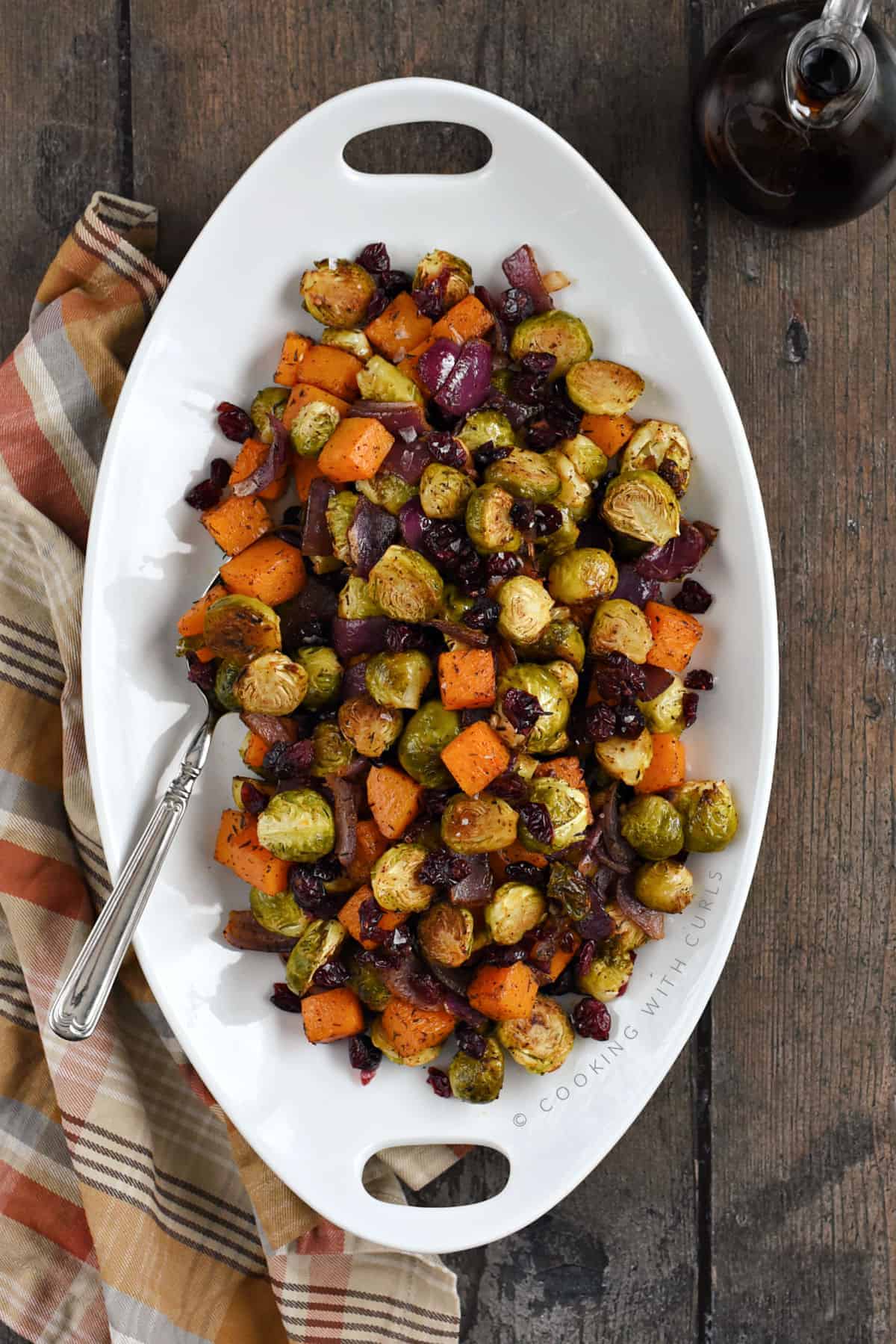 Roasted Brussels Sprouts and Squash with Dried Cranberries on a large, white platter.