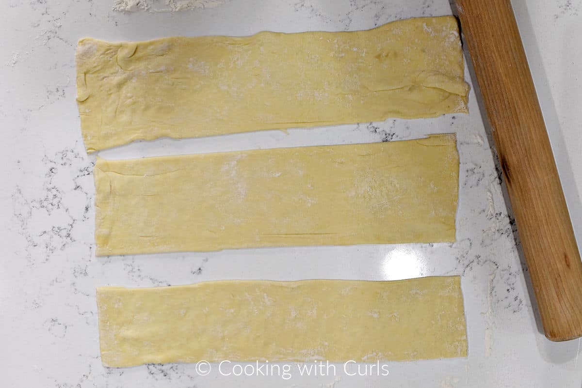 A sheet of puff pastry cut into three strips. 