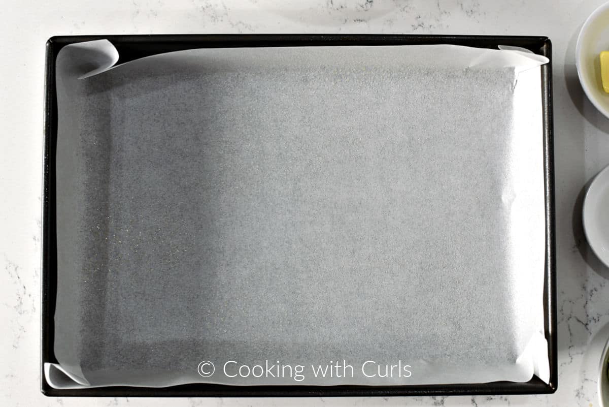 Baking pan with parchment paper and cooking spray. 
