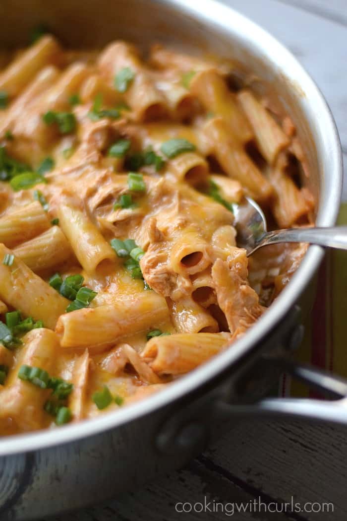 Tube pasta mixed with red sauce in a large skillet.