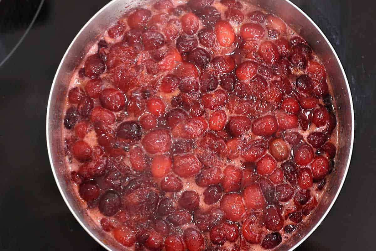 Cranberry sauce simmering in a saucepan. 