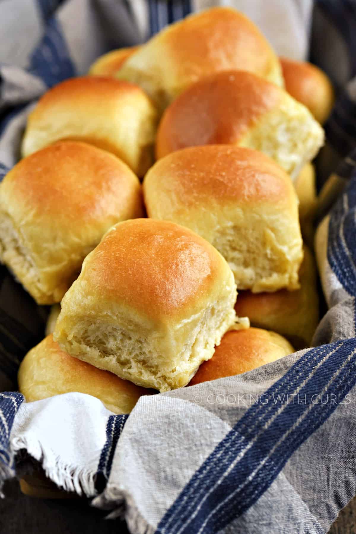 Quick Dinner Rolls piled high in a blue and white towel lined basket.