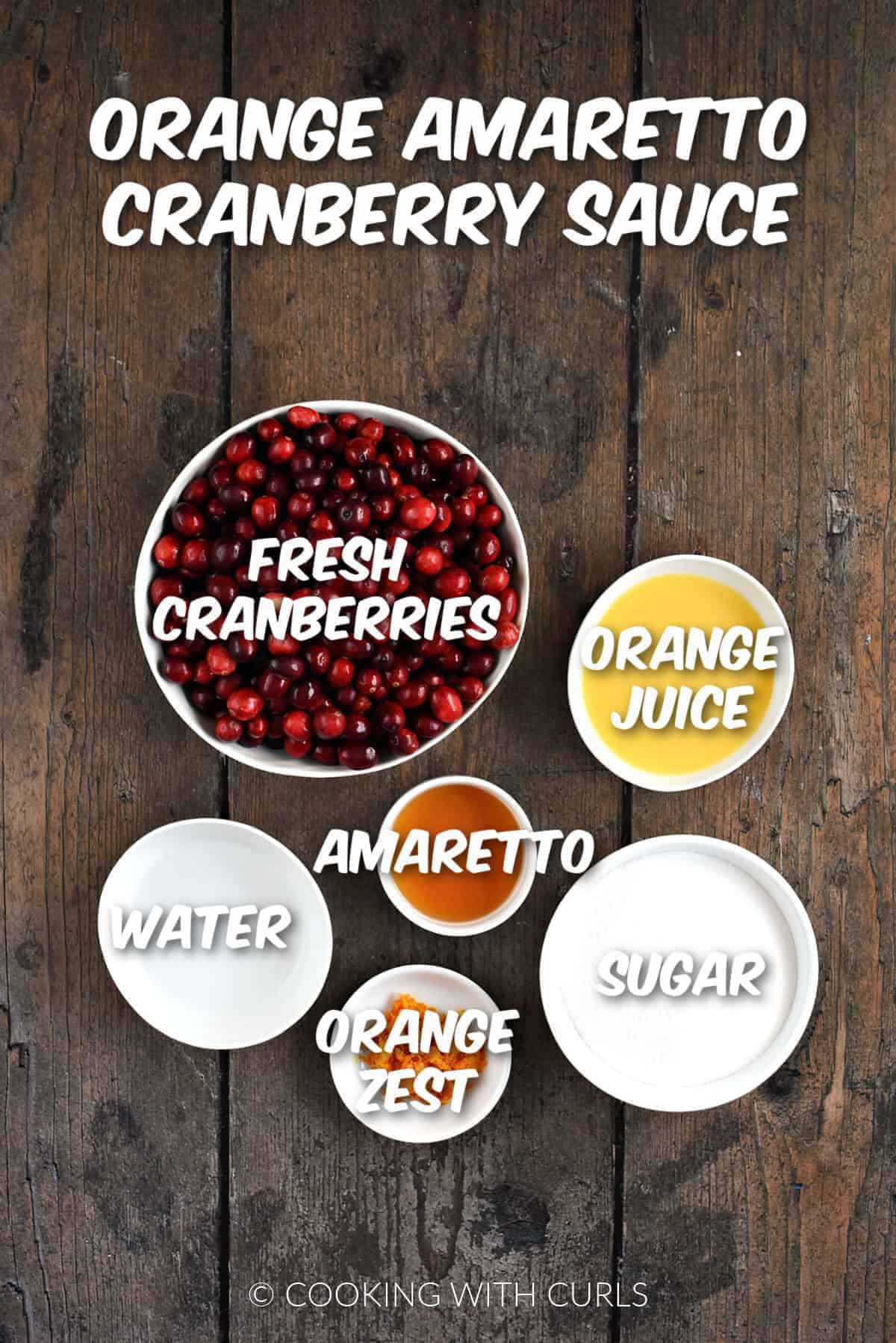 Fresh cranberries, orange juice and zest, sugar, water, and amaretto in bowls. 