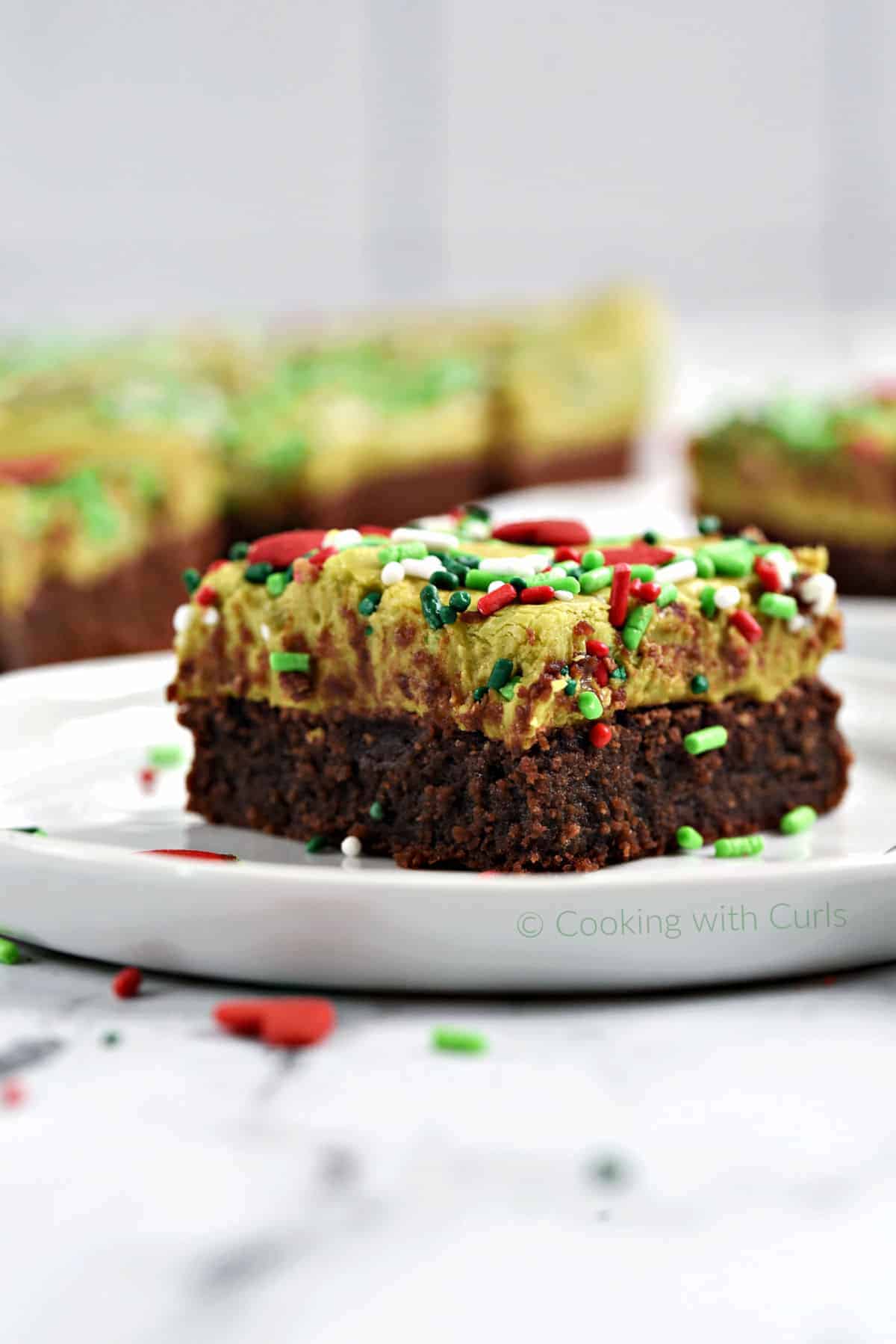 Fudgy Grinch Brownies on small white plates. 