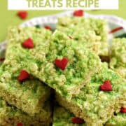 A pile of green rice krispie treats with red hearts piled on a plate with title graphic across the top.