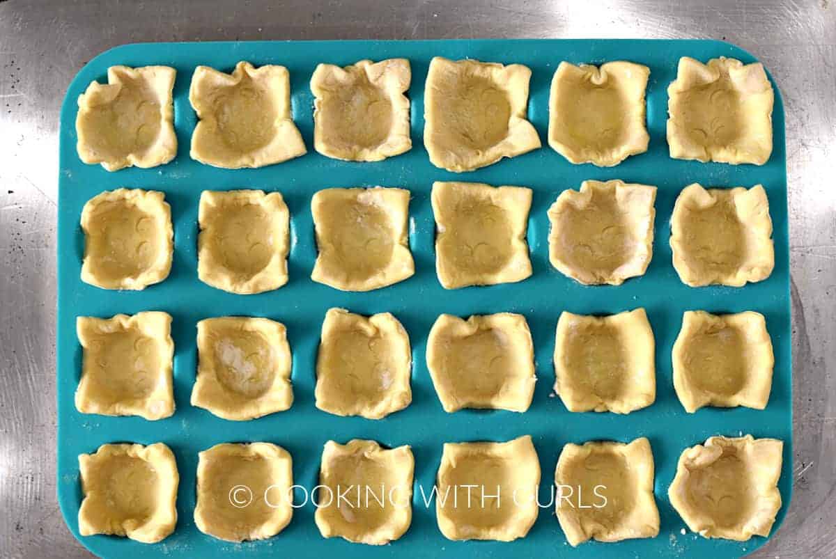 Mini muffin tin filled with twenty four puff pastry squares. 