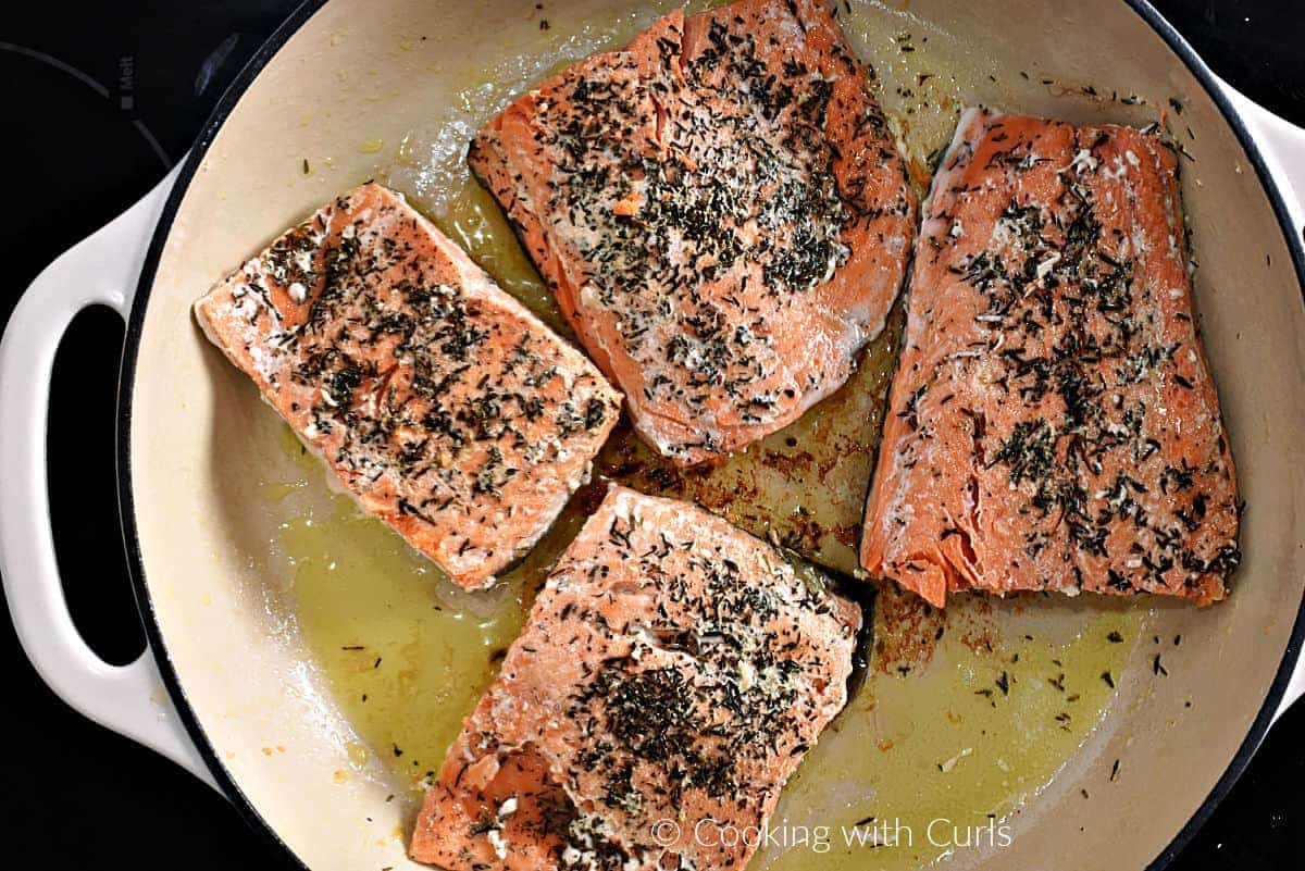 Pan seared salmon filets in a skillet. 