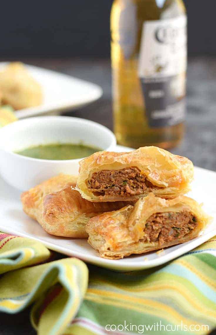 Puff Pastry Chorizo Rolls on a small plate with cilantro dipping sauce on the side.