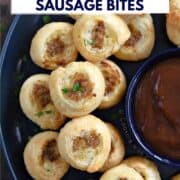 Looking down on a stack of puff pastry sausage bites on a large plate with a bowl of dipping sauce in the center and title graphic across the top.