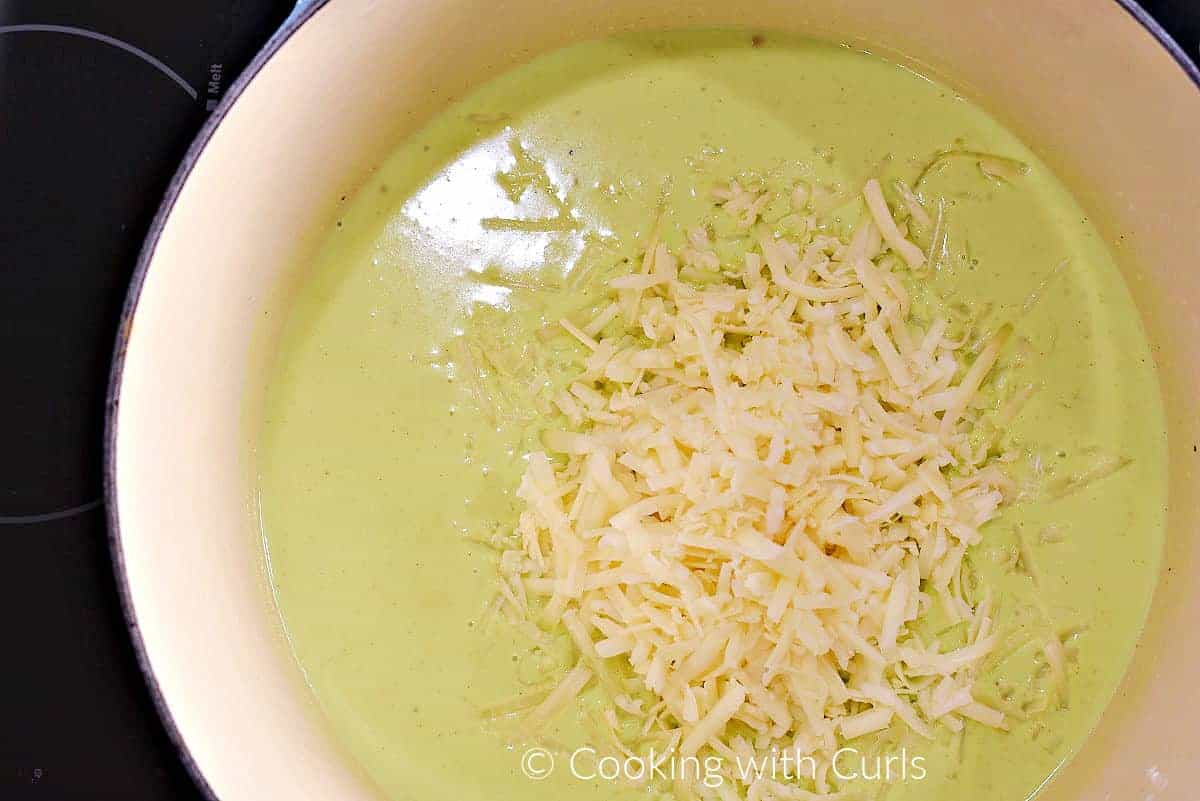 Grated white cheddar added to the green colored sauce.