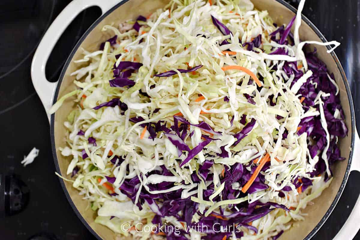 Shredded cabbage and ground pork in a cast iron skillet. 
