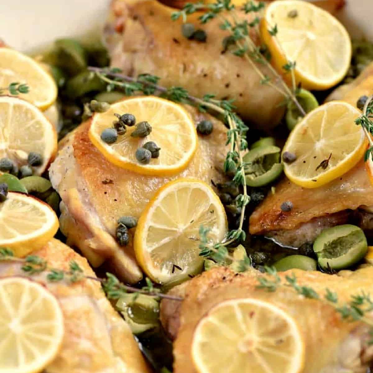 Chicken thighs with olives, capers, and lemon slices.