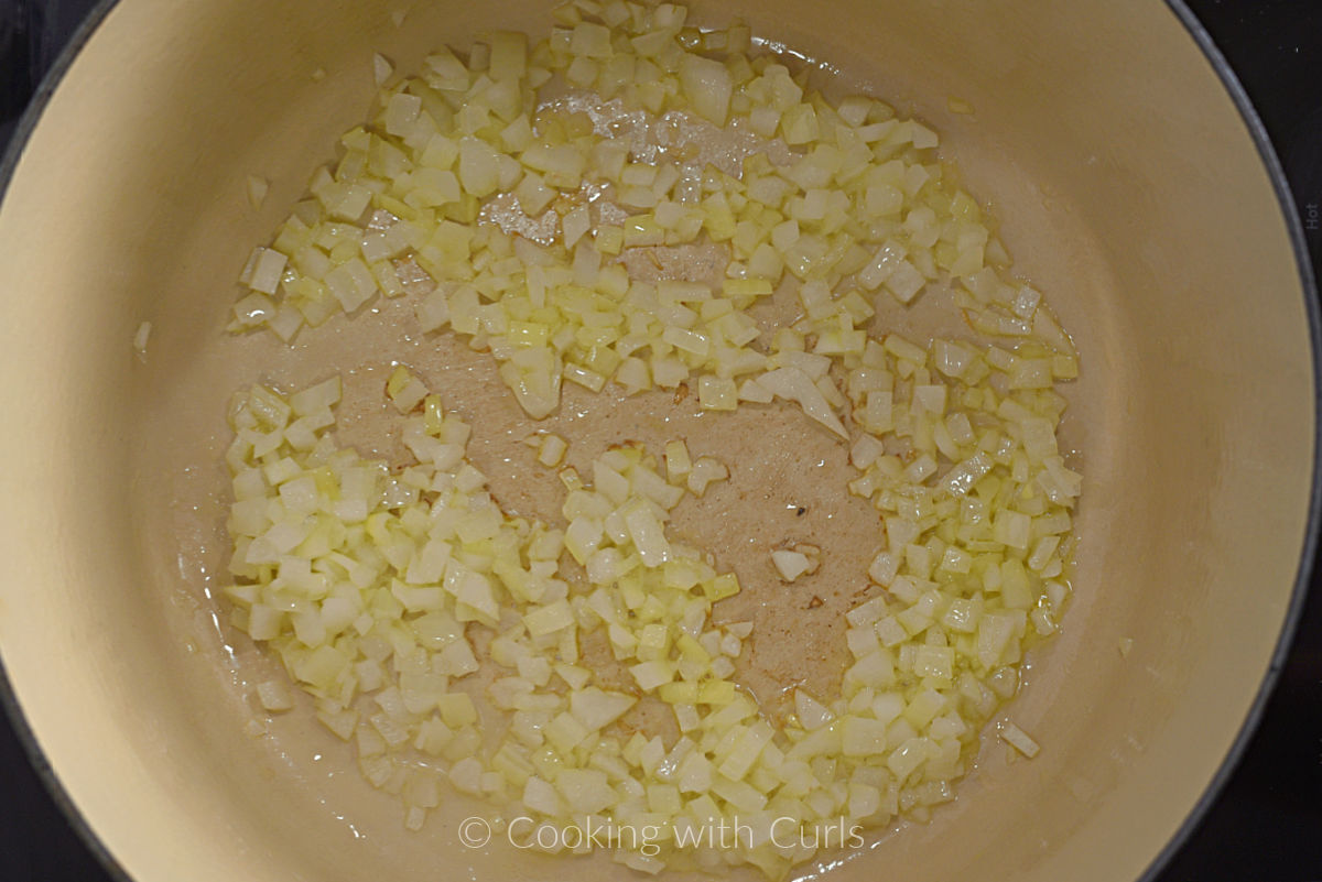 Diced onions cooking in a Dutch oven. 