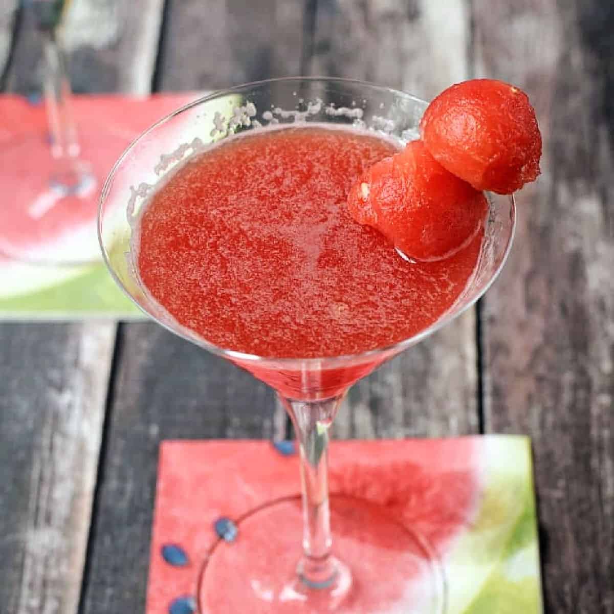 Watermelon Martini in a martini glass garnished with two watermelon balls on a skewer.