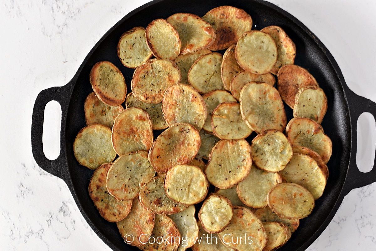 Baked potato slices in a cast iron skillet. 
