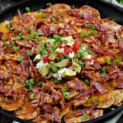 Corned Beef Irish Nachos with potato slices, melted cheddar cheese, corned beef, bacon, green onions, sour cream, diced tomatoes and avocado chunks.