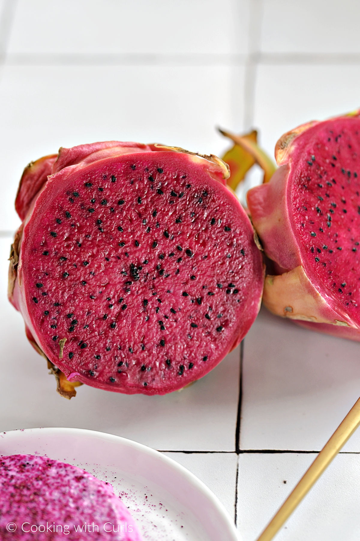 A red dragon fruit that has been sliced in half.
